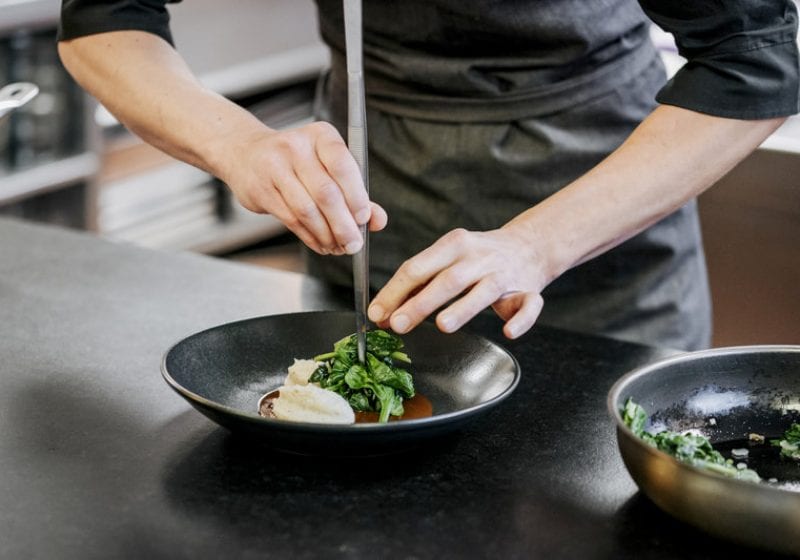 Anrichten-des-Blattspinats-auf-Polentanockerl-c-Angela-Lamprecht-Vorarlberg-Tourismus