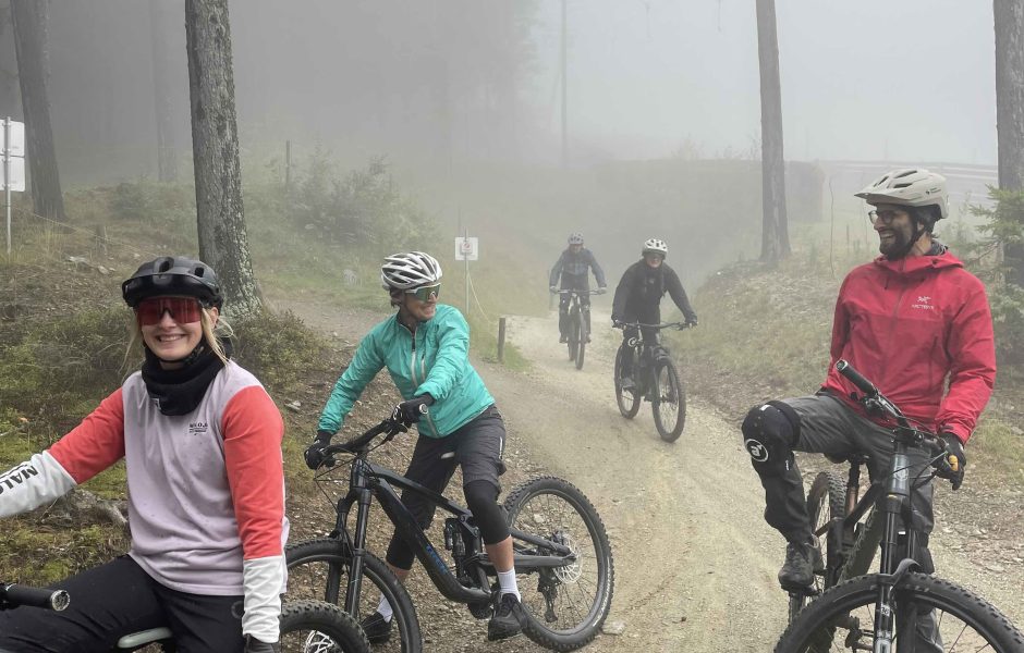 Eine Gruppe von fünf Personen sitzen auf einem Mountainbike im Wald